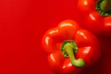 赤い背景の上に置かれた赤いパプリカ
