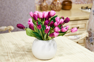 Bouquet of tulips in white vase on table