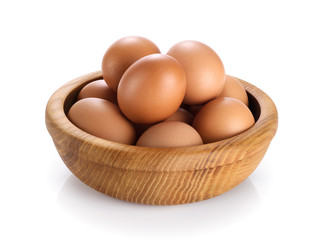 Wooden bowl with eggs isolated on white background.