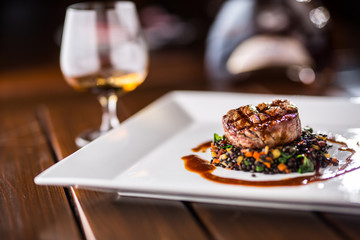 Beef Steak. Grill beef steak black lentils mixed with vegetable. Cognac or brandy as drink. Culinary food in hotel pub or restaurant