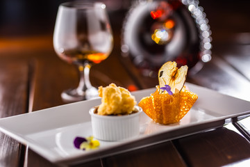 Sweet cake with peas ice cream in caramel basket. Culinary food - sweet dessert cognac or brandy in hotel pub or restaurant