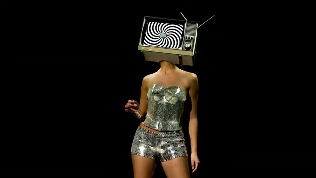 amazing woman in metallic costume dancing and posing with a television as a head. the tv is has a hypnotic video looping on it
