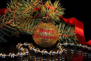 красивый новогодний фон с елочной игрушкой и веточкой ели на черном фоне       