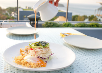 Japaneses salad fusion with egg onsen on white plate