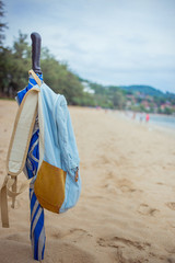 Folded umbrella stuck in the sand. The umbrella weighs backpack. Beach, Sea, Thailand Kata. Tropics