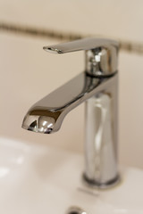  Silver faucet over a sink closeup