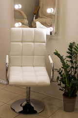  White quilted chair with a backrest for hands on a silver leg