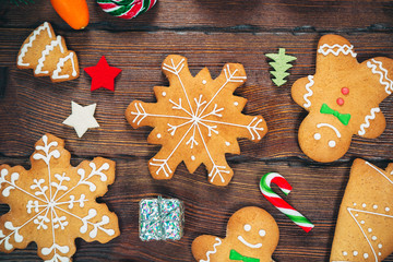 Christmas gingerbread cookies homemade on wooden table with candies and New Year decorations. Xmas background