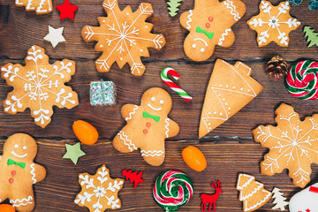 Christmas gingerbread cookies homemade on wooden table with candies and New Year decorations. Xmas background