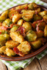 roasted brussels sprouts in breadcrumbs with crispy bacon close-up on plate. vertical