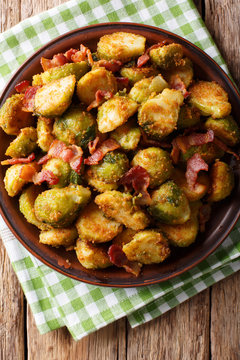 roasted brussels sprouts in breadcrumbs with crispy bacon close-up on plate. Vertical top view