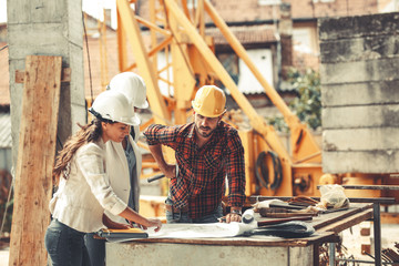 Two female inspectors and architects discuss with head engineer about construction project.People...