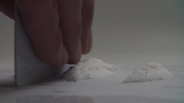 Man splits cocaine drugs on the table 