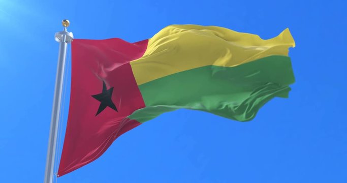 Flag of Guinea Bissau waving at wind in slow in blue sky, loop
