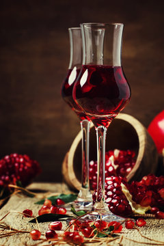 Pomegranate liqueur, still life in rustic style, vintage wooden background, selective focus