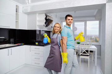 Young family couple doing cleaning in the house. Home cleaning.