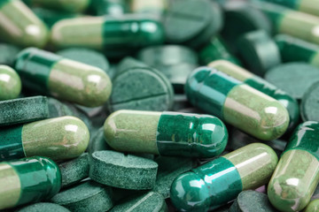 Healthy spirulina capsules and tablets, closeup