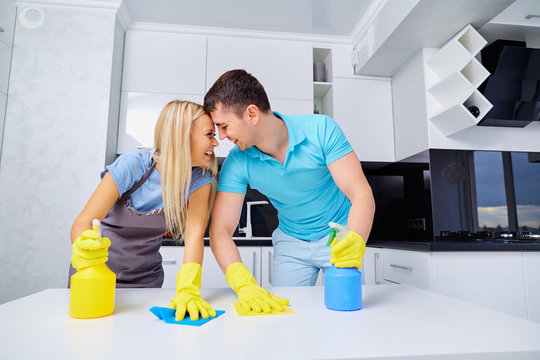 Young family couple doing cleaning in the house. Home cleaning.