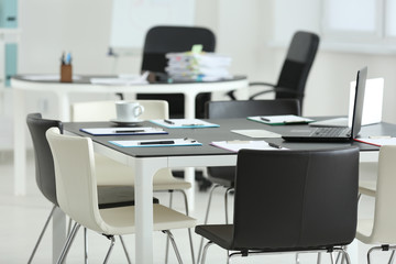 Clipboards with documents and laptop on table in office