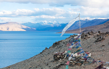 Stone chorten with Lungta flags on Tso Moriri lake in Ladakh, North India