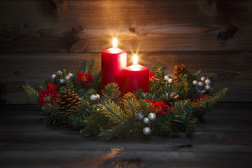 Second Advent - Decorated Advent wreath with two red burning candles on a wooden background with...