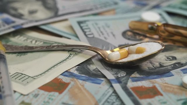 Pills, drugs, cocaine, syringe on dollar bank notes. Dolly shoot.