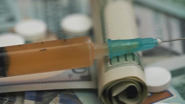 Pills, drugs, cocaine, syringe on dollar bank notes. Dolly shoot.