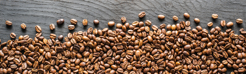 Roasted coffee beans on wooden table. Top view.