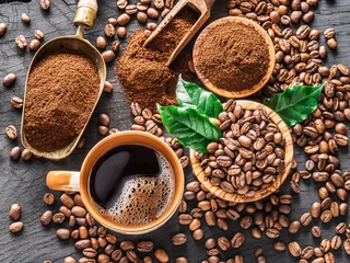 Tuinposter Roasted coffee beans, ground coffee and cup of coffee on wooden table. © volff