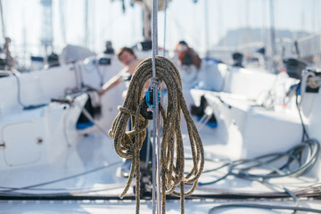 Nautical ropes, buntine, capstan and cablet piled up on deck of professional racing yacht or sailboat, attached to mast or forestay, different colors, expensive sailing hobby