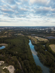 Fototapeta na wymiar Aerial view of river surrounded by tree in a cloudy day.