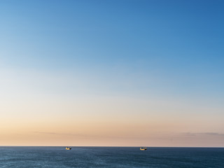 Calm sea and cloudless orange evening sky.