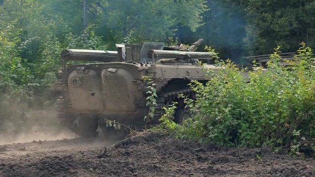 Military tank moving on background destroy building during hostilities
