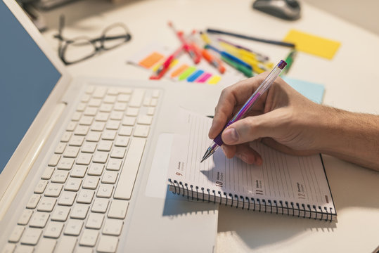 Close-up Of A Businessperson's Hand Writing Schedule In Diary With Pen