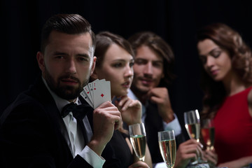 Poker player to four aces over dark background