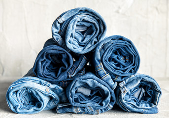 roll blue denim jeans on gray background