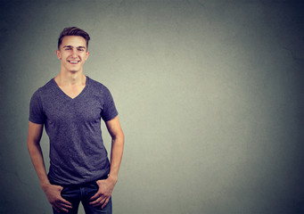 Portrait of a happy casual man smiling isolated on gray background  