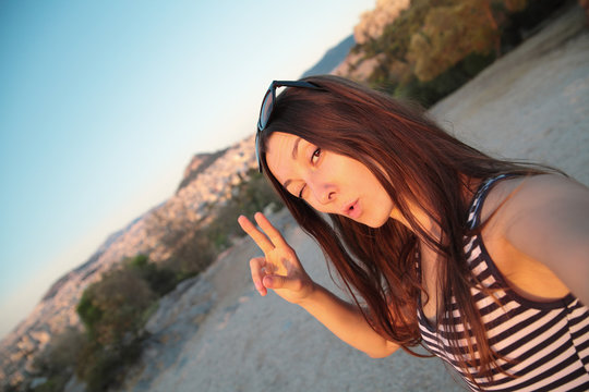 Girl taking self portrait on the background of Athens sights,Greece.Travel selfie.