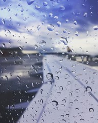 Blick aus dem Fenster einen Flugzeugs am Boden bei Regen