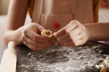 Process of making ravioli, pelmeni or dumplings with meat on wooden table