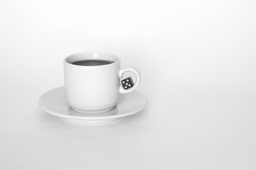 A cup of coffee with dice on white background