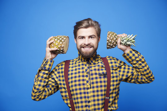 Cheerful man with a pineapple at studio shot