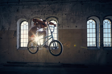 The BMX rider jumps with a bicycle.