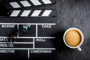Screenwriter desktop with movie clapper board dark background to