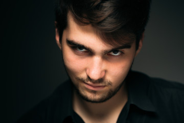 young brunette guy on a dark background