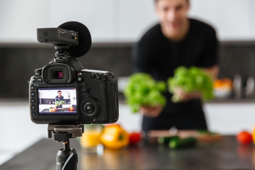 Close up of a video camera filming young male blogger