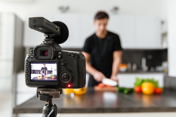 Close up of a video camera filming young male blogger