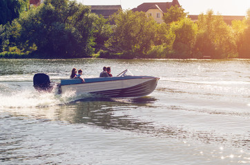 Fototapeta premium Motor boat with people floating on the river
