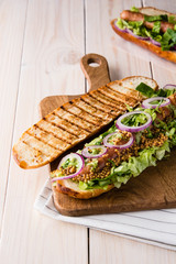 Grilled hot dog with sausage, mustard and salad.