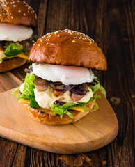 Burgers with fried onions, meat, eggs and fresh salad.